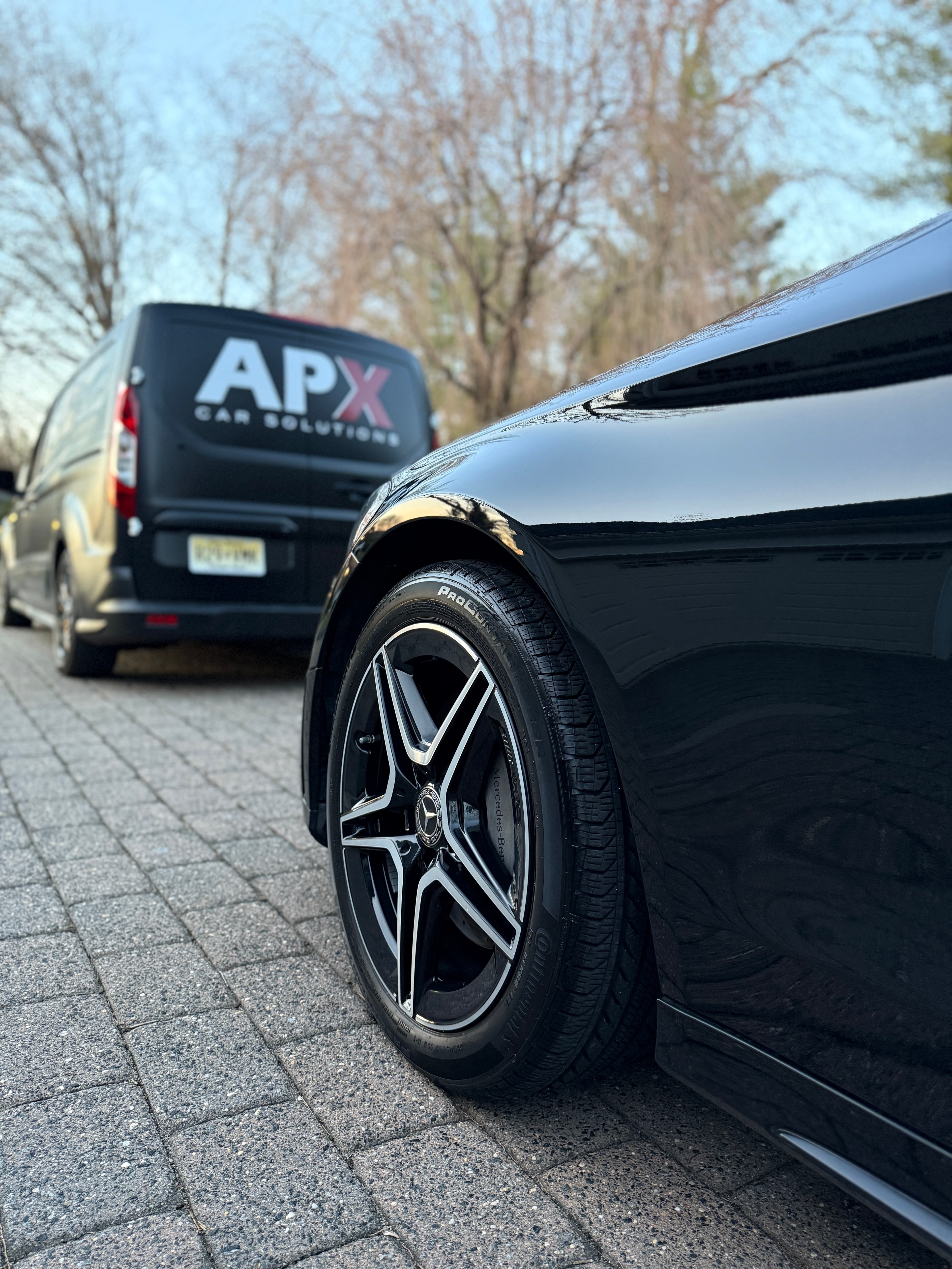 Spotless Mercedes-Benz wheel and gloss-black paint with the APX van parked behind it