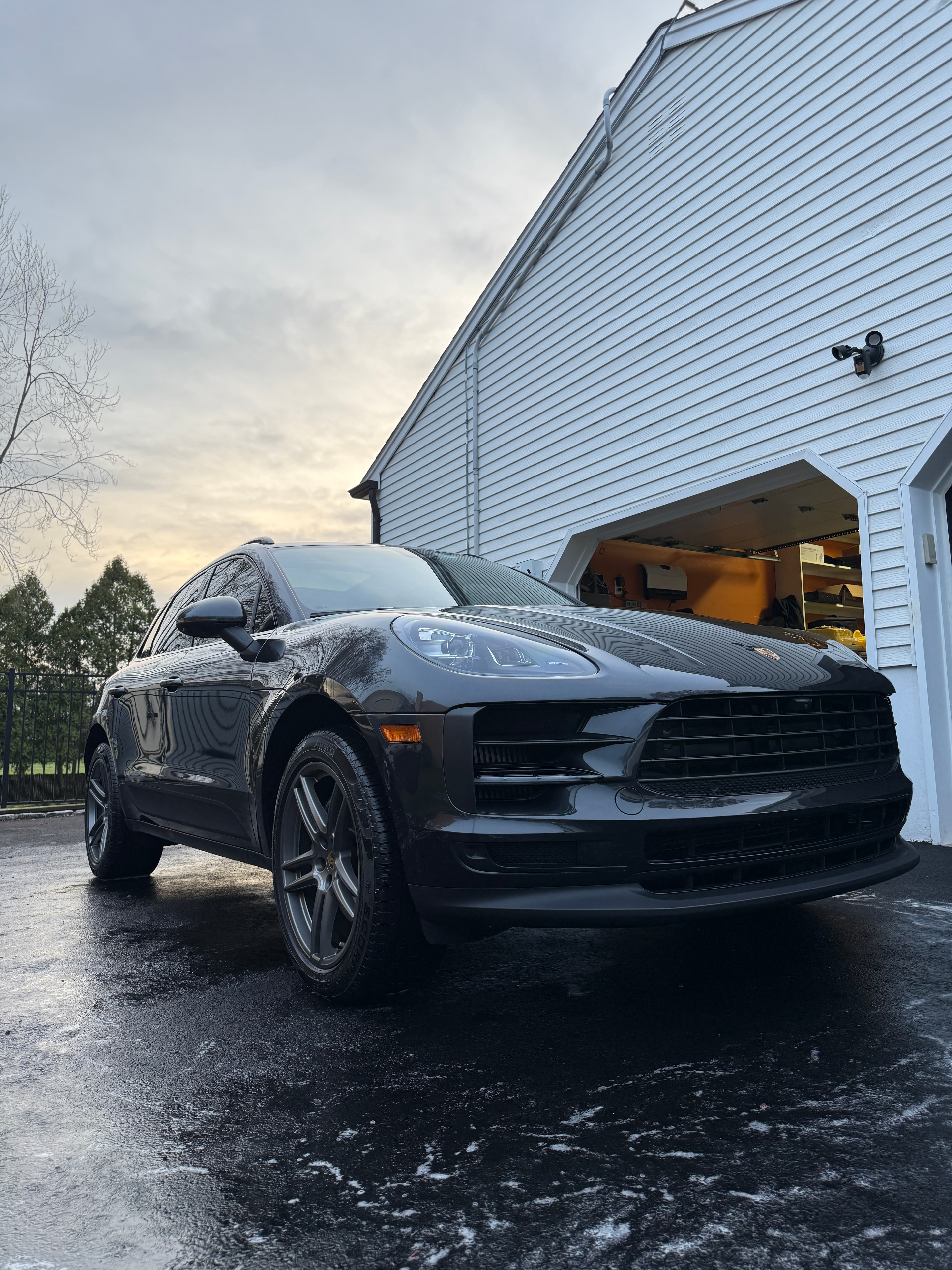 Black Porsche Macan with a deep wet-look gloss across the hood and front end