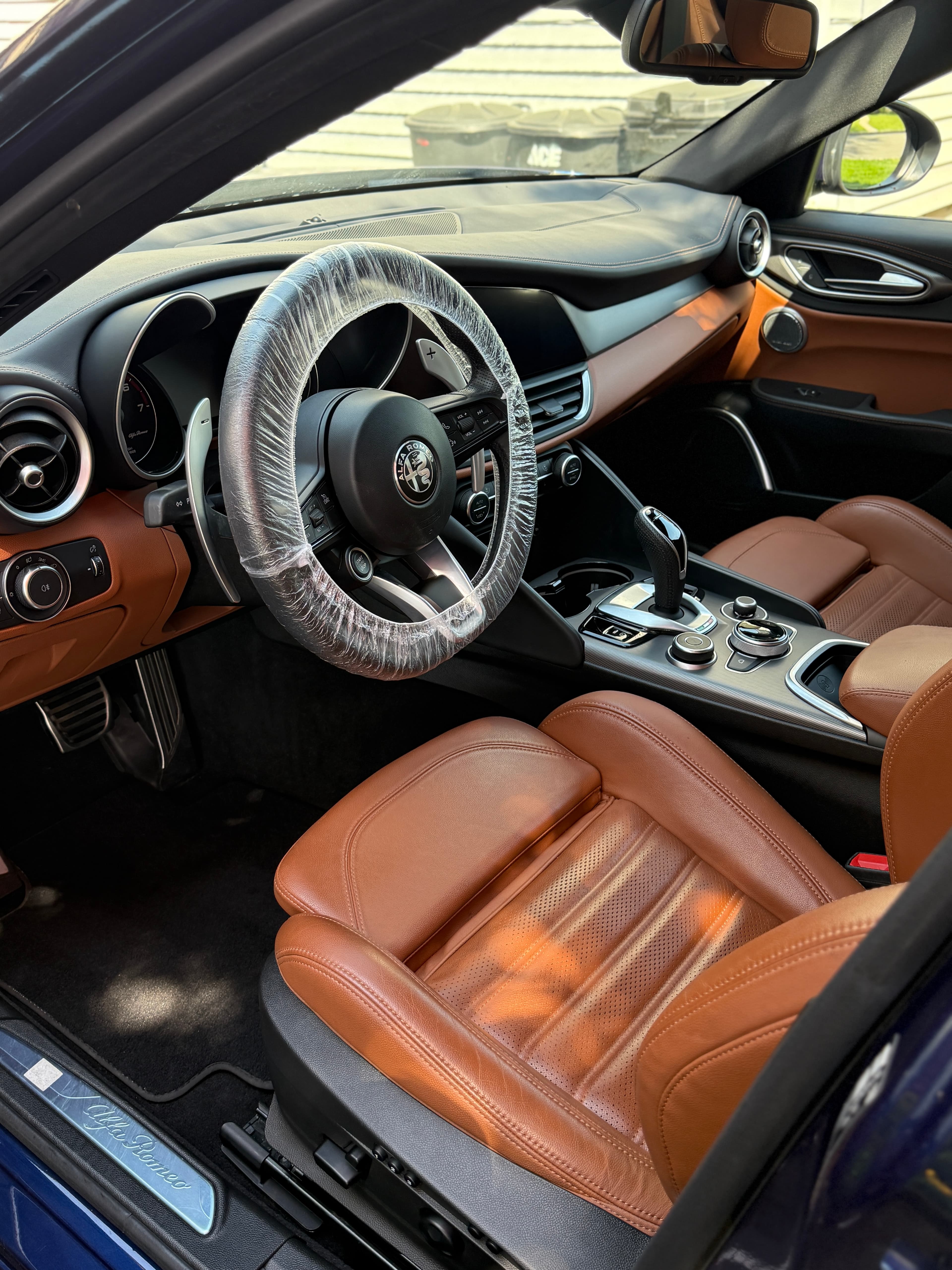 Tan leather interior of an Alfa Romeo Giulia mid-detail in an Emerson driveway
