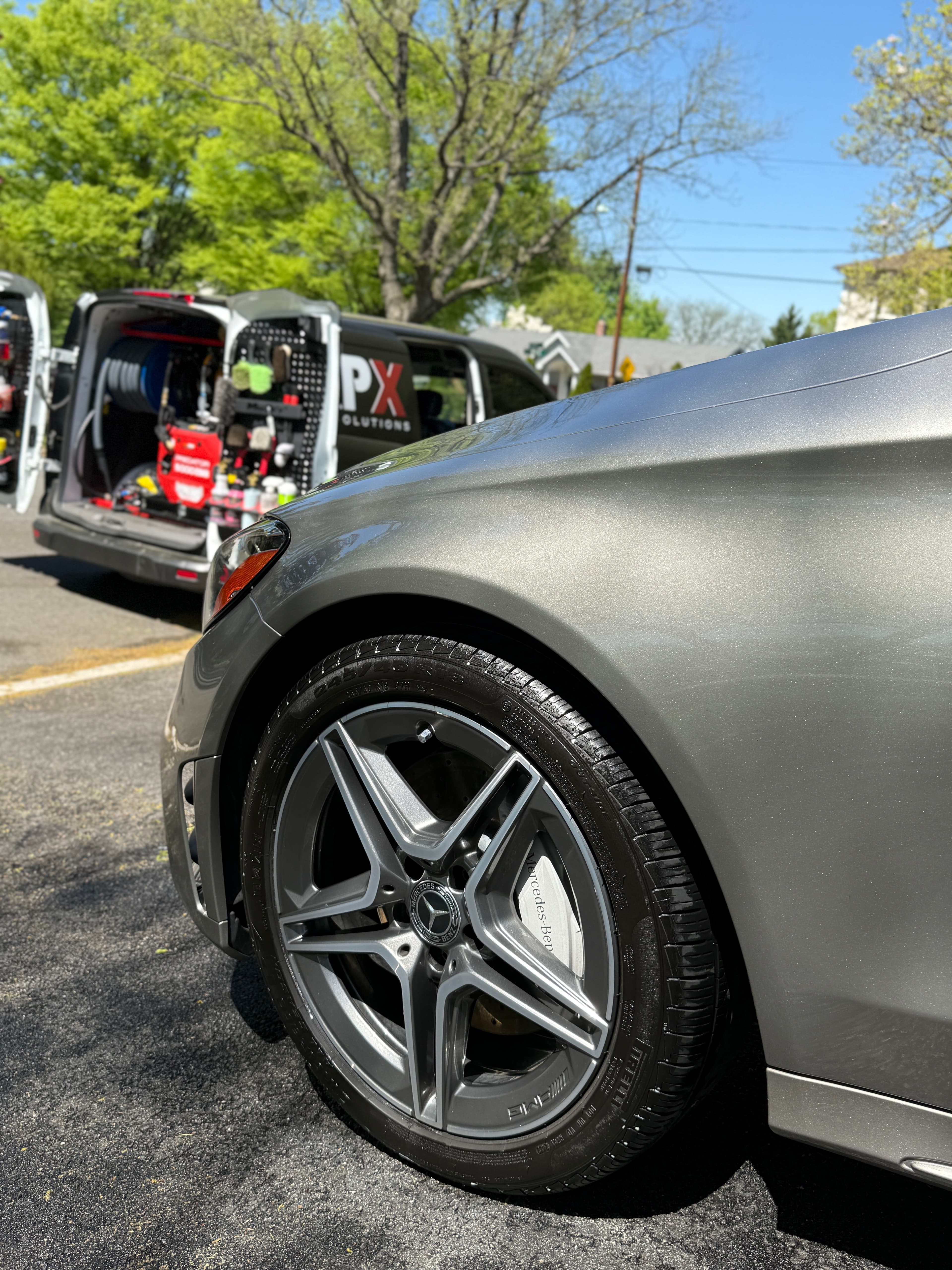 Polished Mercedes-AMG wheel beside the fully stocked APX van in Saddle River