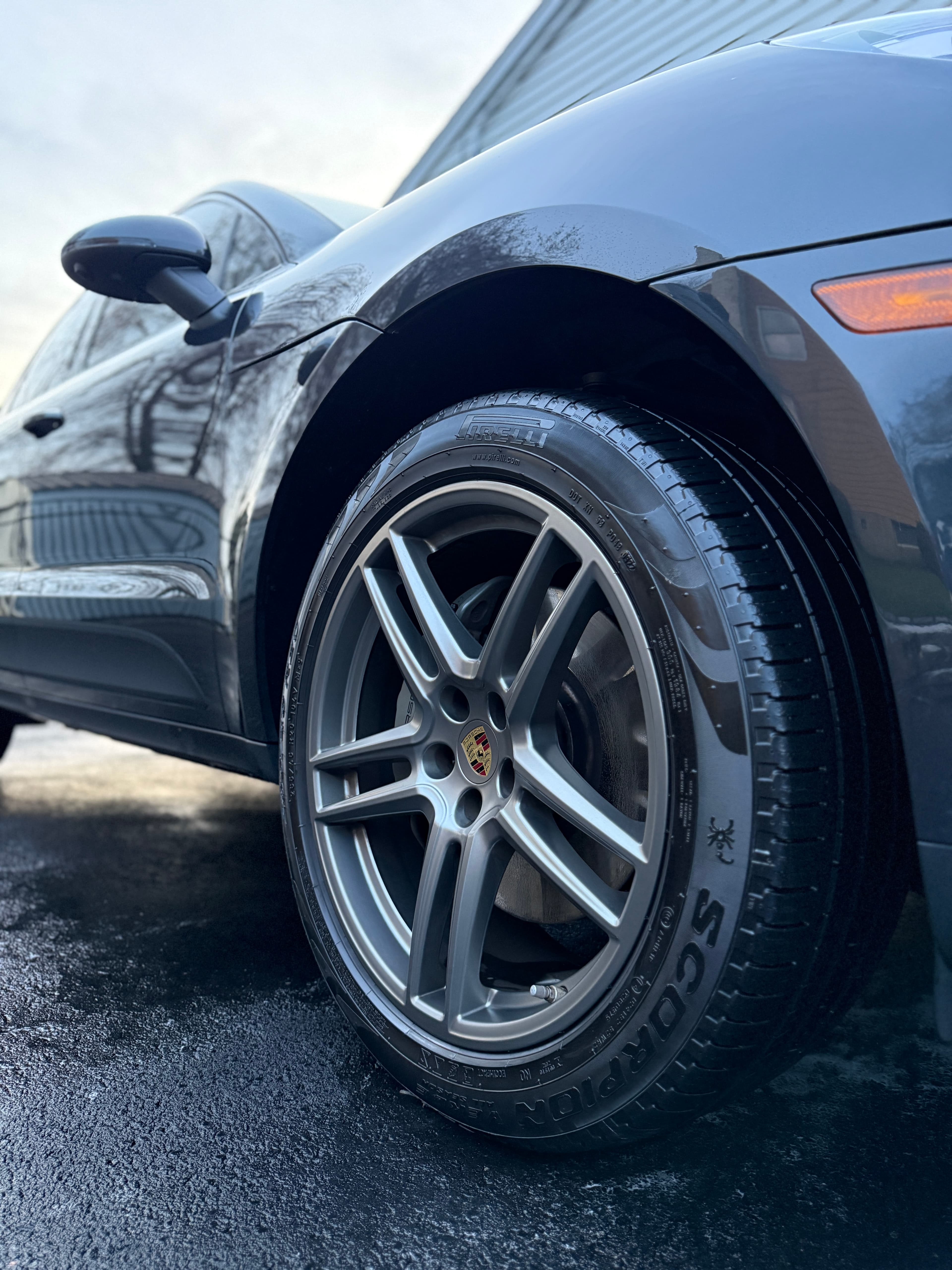 Detailed Porsche Macan wheel and freshly dressed tire in an Old Tappan driveway