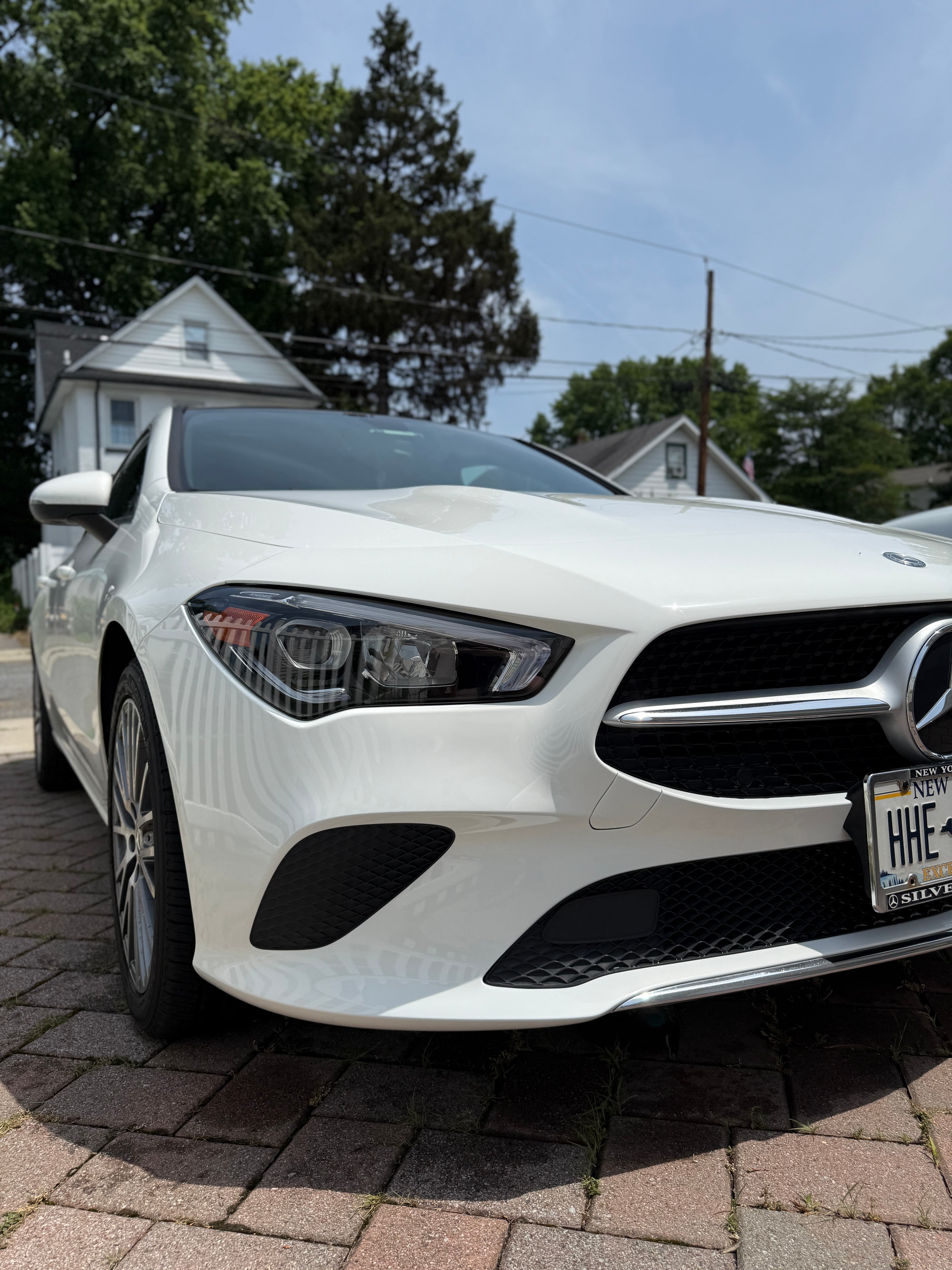 White Mercedes-Benz CLA freshly washed and detailed in a Fair Lawn driveway